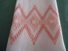 an orange and white tie on a green table