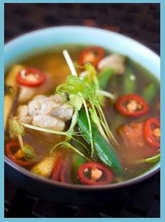 a blue bowl filled with soup and vegetables