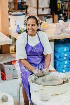 a woman in an apron is working on a wheel