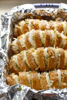 several pieces of bread wrapped in tinfoil on top of each other and sprinkled with parmesan cheese