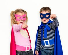 two children dressed up as superheros pointing at the camera