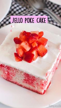 a piece of cake with white frosting and strawberries on top is sitting on a plate