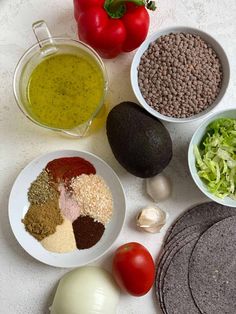 the ingredients for an avocado salad laid out on a white counter top, including tomatoes, onions, lettuce, and beans