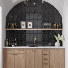 a kitchen with wooden cabinets and black tile backsplash, white countertops and gold accents