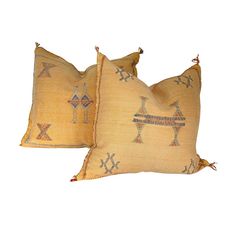 two yellow pillows with decorative designs on them