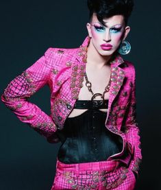 a woman in pink and black is posing with her hands on her hips while wearing an unusual outfit