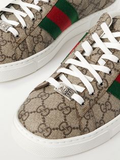 Launched in 2016, Gucci's 'Ace' sneakers quickly gained a massive following and have seen countless renditions ever since. This version has been made in Italy from coated-canvas jacquard-woven with the house's 'GG Supreme' monogram and detailed with signature striped webbing. Contrasting green leather heel tabs add a final pop of colour. Shop Gucci, Gucci Collection, Gucci Shoes Sneakers, Luxury Sneakers, Sneakers For Men, Fine Jewelry Designers, Slides Shoes, Classic Sneakers, Derby Shoes