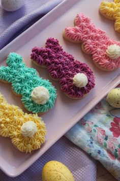 some decorated cookies are on a pink plate