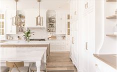 a large kitchen with white cabinets and wood flooring on the walls, along with an island in the middle