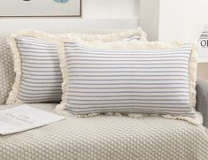 two blue and white pillows sitting on top of a couch next to a pillow case