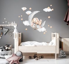 a child's bedroom decorated in gray and white with stars on the ceiling, moon and elephant wall decals