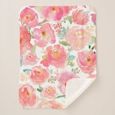 a pink flowered blanket on top of a white table