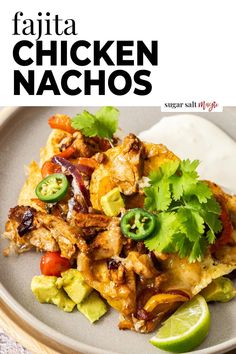 chicken nachos on a plate with cilantro and lime