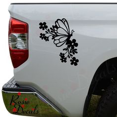 a white truck with black flowers and a butterfly decal