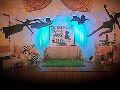 a stage set up for a children's birthday party with silhouettes of people and animals on it