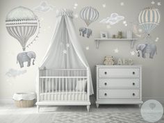 a baby's nursery room with an elephant and hot air balloons wall decal