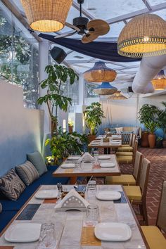 an indoor dining area with tables, chairs and hanging lights in the ceiling above them