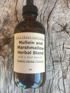 a bottle of mullein and marshmallow herb blend on a wooden surface