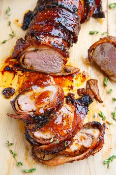 sliced meat on a wooden cutting board with herbs