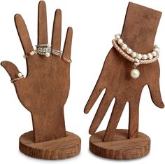 two wooden hand sculptures with pearls on them