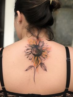 a woman with a sunflower tattoo on her back