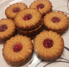 small pastries are arranged on a plate and ready to be eaten with jelly in the middle