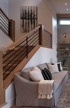 a living room filled with furniture next to a stair case