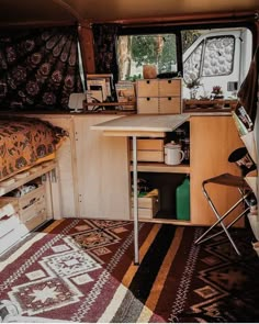 the inside of a camper with a bed and desk