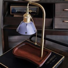 a desk lamp sitting on top of a wooden table next to a bookshelf