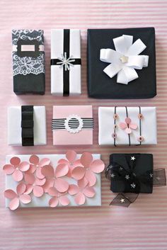 an image of gift boxes with flowers and ribbons on the top one is black, white and pink