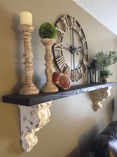 a clock mounted to the side of a wall next to a shelf with vases on it