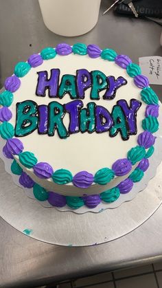 a birthday cake with the words happy birthday written on it in purple and green frosting