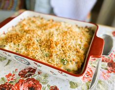 a casserole dish with cheese and broccoli in it on a table