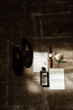 a pair of brown shoes sitting on top of a floor next to an open book