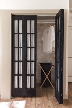 an open door leading to a closet with clothes on hangers