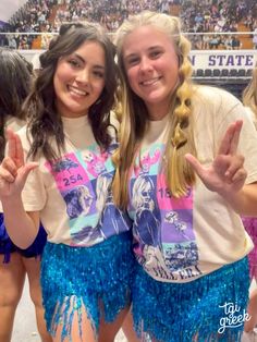 two girls in cheerleader outfits posing for the camera