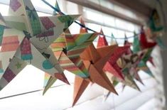 several colorful paper stars hanging from a window