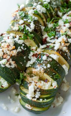 zucchini stuffed with feta cheese and herbs on a white plate, ready to be eaten