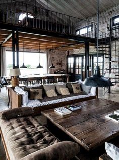 a living room filled with lots of furniture next to a brick wall and flooring