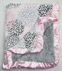 a pink and gray blanket with flowers on it