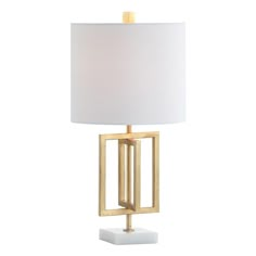 a table lamp with a white shade on the base and a gold frame around it