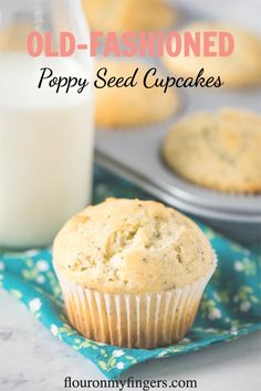 old - fashioned poppy seed cupcakes on a blue napkin next to a glass of milk