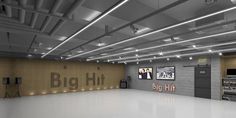 an empty room with big hit signs on the wall and lights hanging from the ceiling