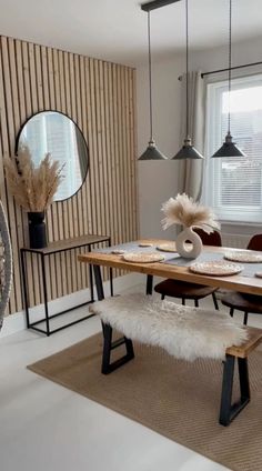 a dining room table with chairs and a bench in front of a large window that has wooden slats on the wall