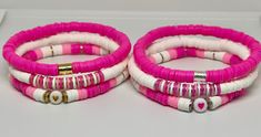 two pink and white bracelets sitting on top of a table