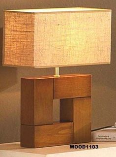 a lamp sitting on top of a table next to a bookshelf and a book