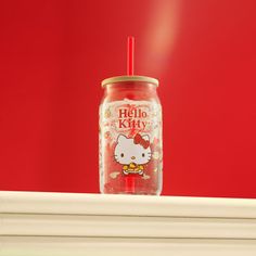 a hello kitty cup with a straw in it on top of a fireplace mantel