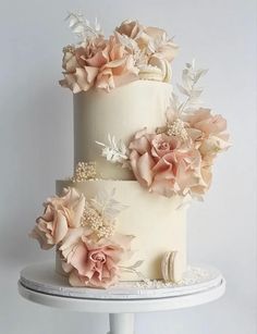 there is a three layer cake with flowers on it