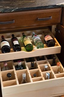 an open drawer with wine bottles in it