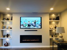 a flat screen tv mounted on the wall above a fireplace